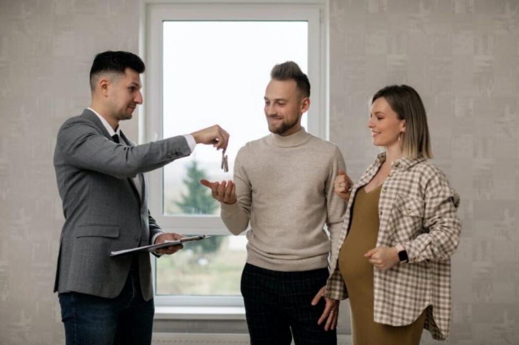 agent handing keys to a couple